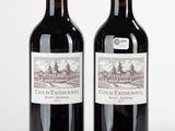deux bouteilles de vin posées l'une à côté de l'autre sur une surface blanche