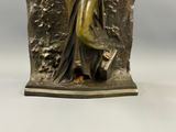 statue d'une femme tenant un livre dans la main droite