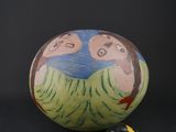 a ball with a painting on it next to a toy car