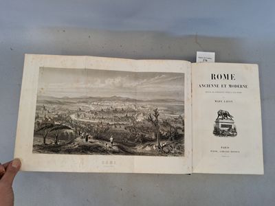 quelqu'un tient un livre dans lequel figure l'image d'une ville