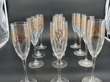 six verres à vin ornés de motifs dorés sont alignés sur une table