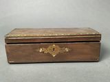 an old wooden box with a gold decoration on the lid