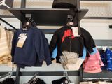 a rack of clothes and hats on display in a store