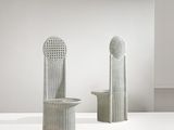 deux vases blancs posés l'un à côté de l'autre sur une table blanche