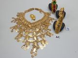 un collier en or, des boucles d'oreilles et une bague posés sur une table