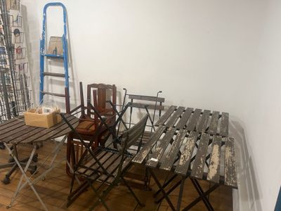 une table et des chaises dans une pièce, avec une échelle en arrière-plan