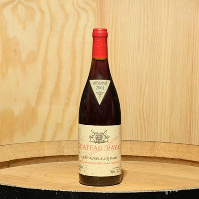 une bouteille de vin posée sur un tonneau en bois