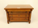 a small wooden chest of drawers with three drawers on each side