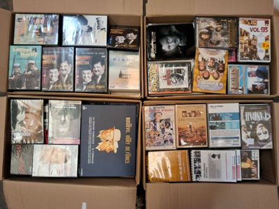 un grand nombre de dvd dans une boîte posée sur le sol
