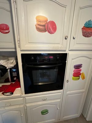 a picture of a kitchen with white cabinets and a black oven