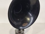 an old black gramphone on a stand on a white surface