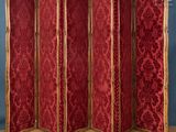 un paravent à quatre panneaux, rouge et or, orné de bordures dorées