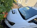 une petite voiture blanche garée sur le bord de la rue