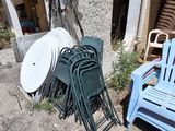 a pile of chairs and a table outside of a building