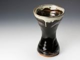 a black and white vase sitting on a white surface