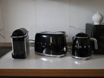 a black toaster, a coffee maker, and a toaster on a counter
