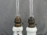 une paire de lampes blanches et dorées ornées de motifs floraux sur fond gris