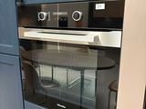 un four au milieu d'une cuisine aux placards bleus