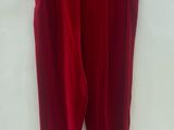a red pants hanging on a hanger on a white wall