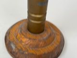 a wooden base with a metal candle holder on top of it