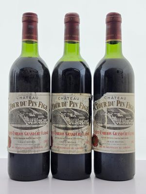 trois bouteilles de vin rouge posées sur une table blanche
