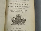 un livre ouvert sur lequel figure une image en noir et blanc représentant une couronne