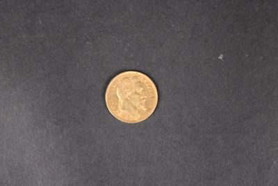 gros plan d'une pièce d'or sur une surface noire