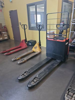 a man that is sitting on a forklift in a warehouse