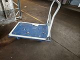 a blue and white hand truck sitting in a parking garage