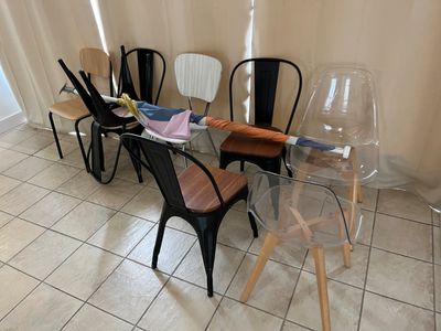 plusieurs chaises et une table dans une pièce aux murs blancs