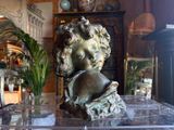 a statue of a boy with a hat on a table
