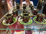 many cups and saucers sitting on a glass table