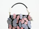 un sac à main noir orné d'une multitude de cœurs roses et bleus