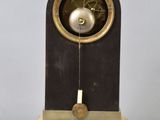 a clock on a stand with a pendulum on it