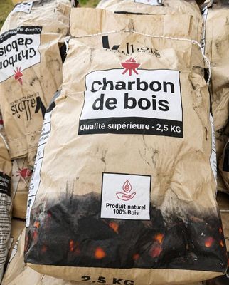 des sacs de charbon de bois sont empilés les uns sur les autres
