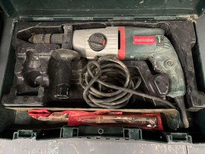 une boîte contenant une perceuse et d'autres outils