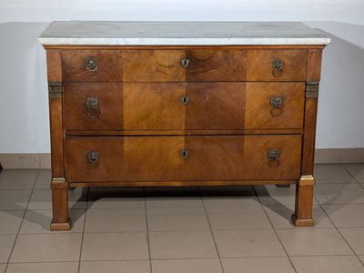 a marble top chest of drawers in the corner of a room