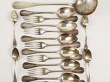 a lot of silver spoons and spoons on the table