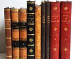 plusieurs vieux livres sont alignés sur une étagère