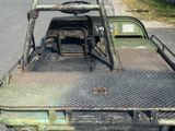 un camion vert avec une benne métallique et un volant