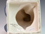 a blue and white vase that has a hole in it