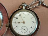 a pocket watch sitting on a table next to a pocket watch