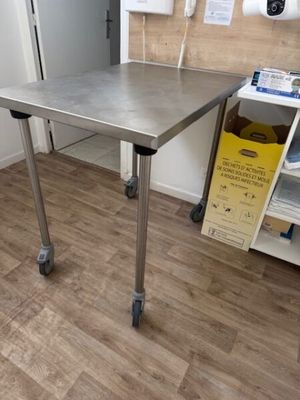 une table en acier inoxydable sur roulettes dans une pièce