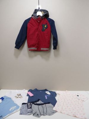 a baby boy ' s clothes on a table in a room