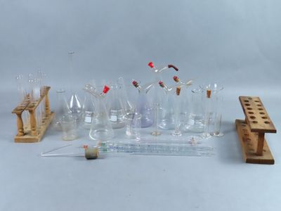 a group of glass bottles and a wooden stand on a white surface