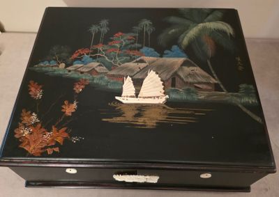 une boîte noire sur laquelle est peinte une barque sur l'eau