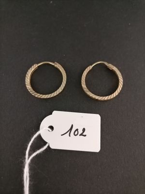 two gold rings and a tag on a black surface