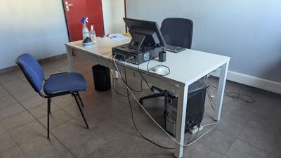 un bureau avec un ordinateur et une chaise dans une pièce