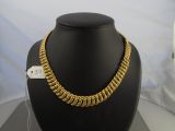 an image of a gold chain necklace on a mannequin display