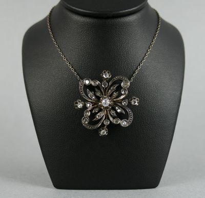 un collier noir et blanc orné d'un motif floral, porté par un mannequin